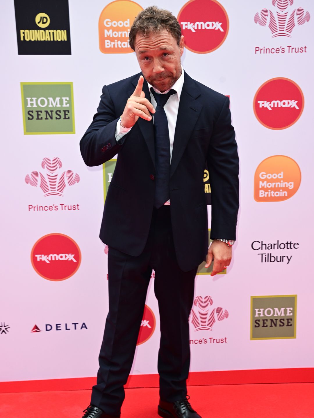 Stephen Graham pointing in a suit