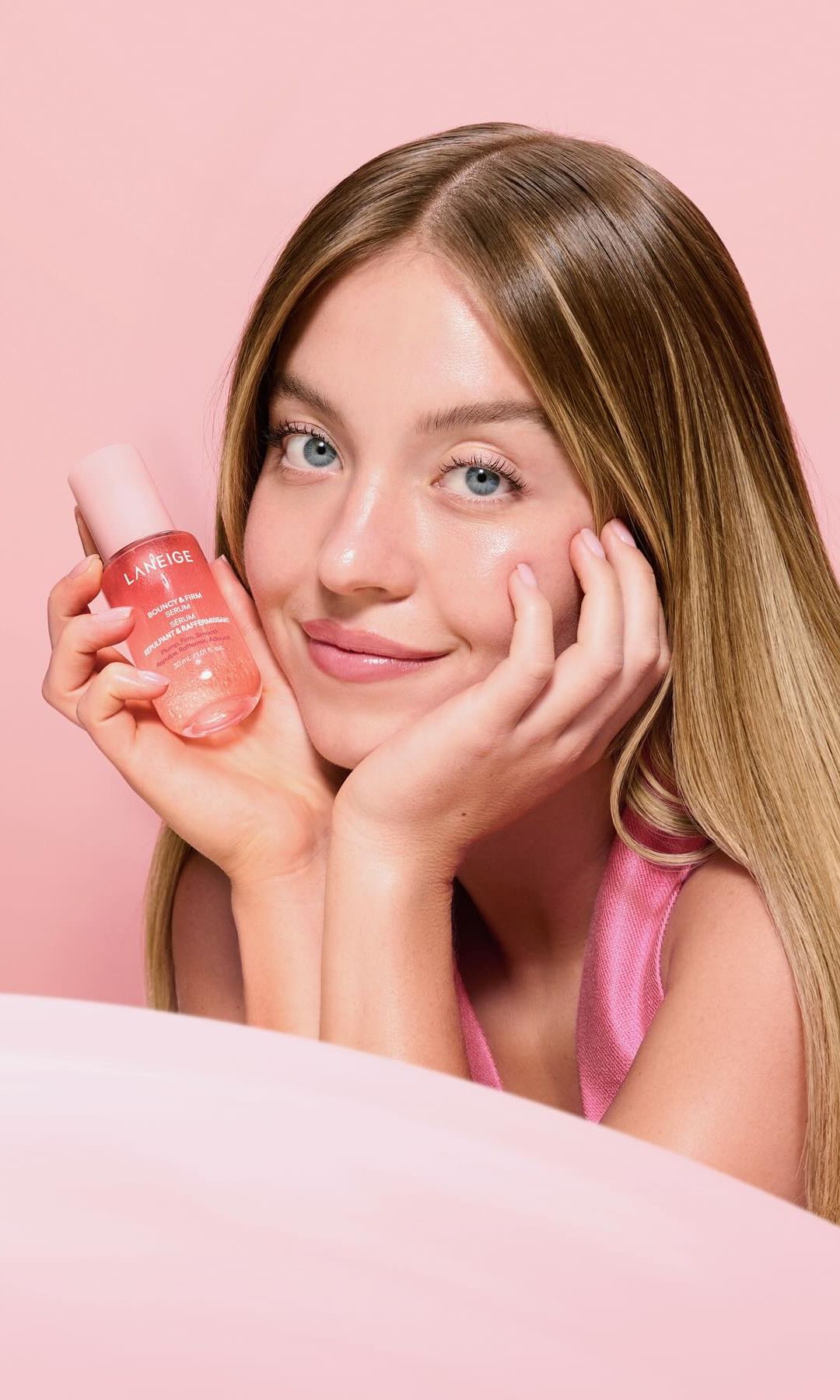 Sydney Sweeney poses on set with Laneige in a pink suit 