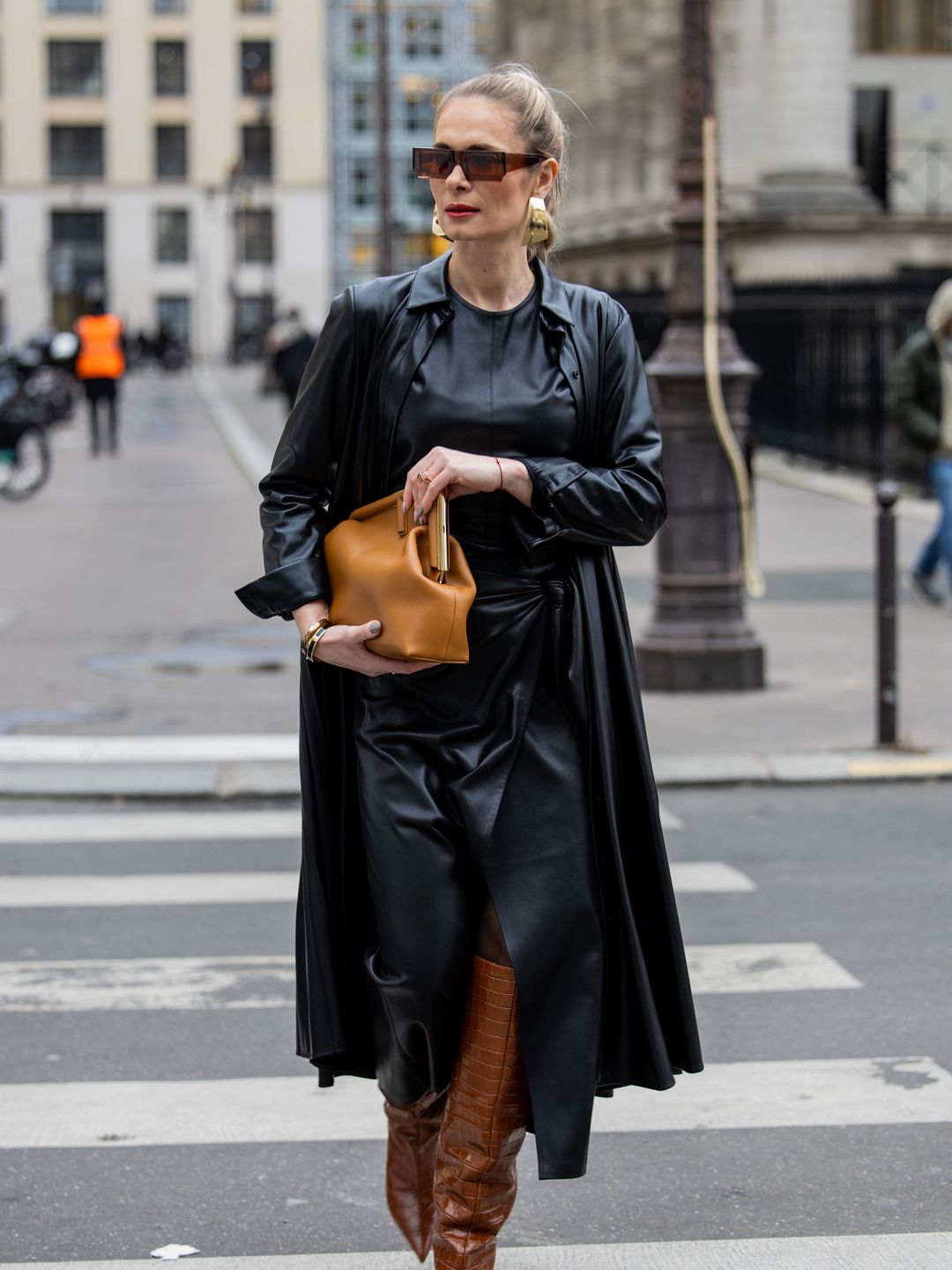  Iryna Thater wears skirt & top and coat sustainable leather from Nanushka, brown knee high boots Jimmy Choo, bag Fendi, Jacquemus sunglasses outside Fendi 