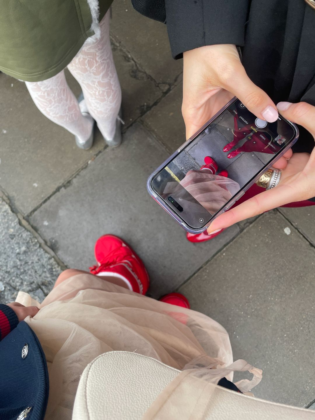 A photo of someone taking a photo of red shoes