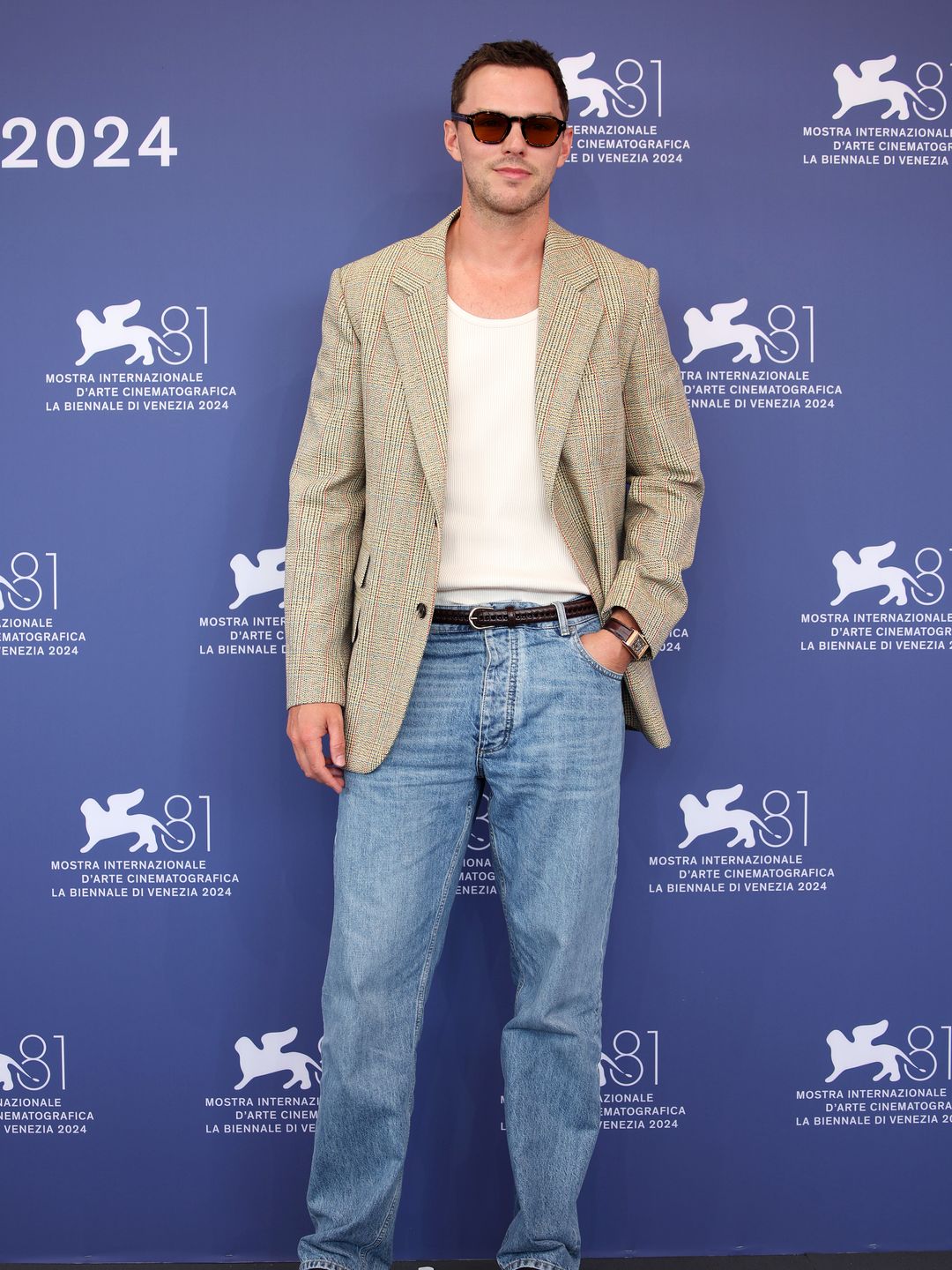 Nicholas Hoult in a tan jacket, white shirt and denim jeans