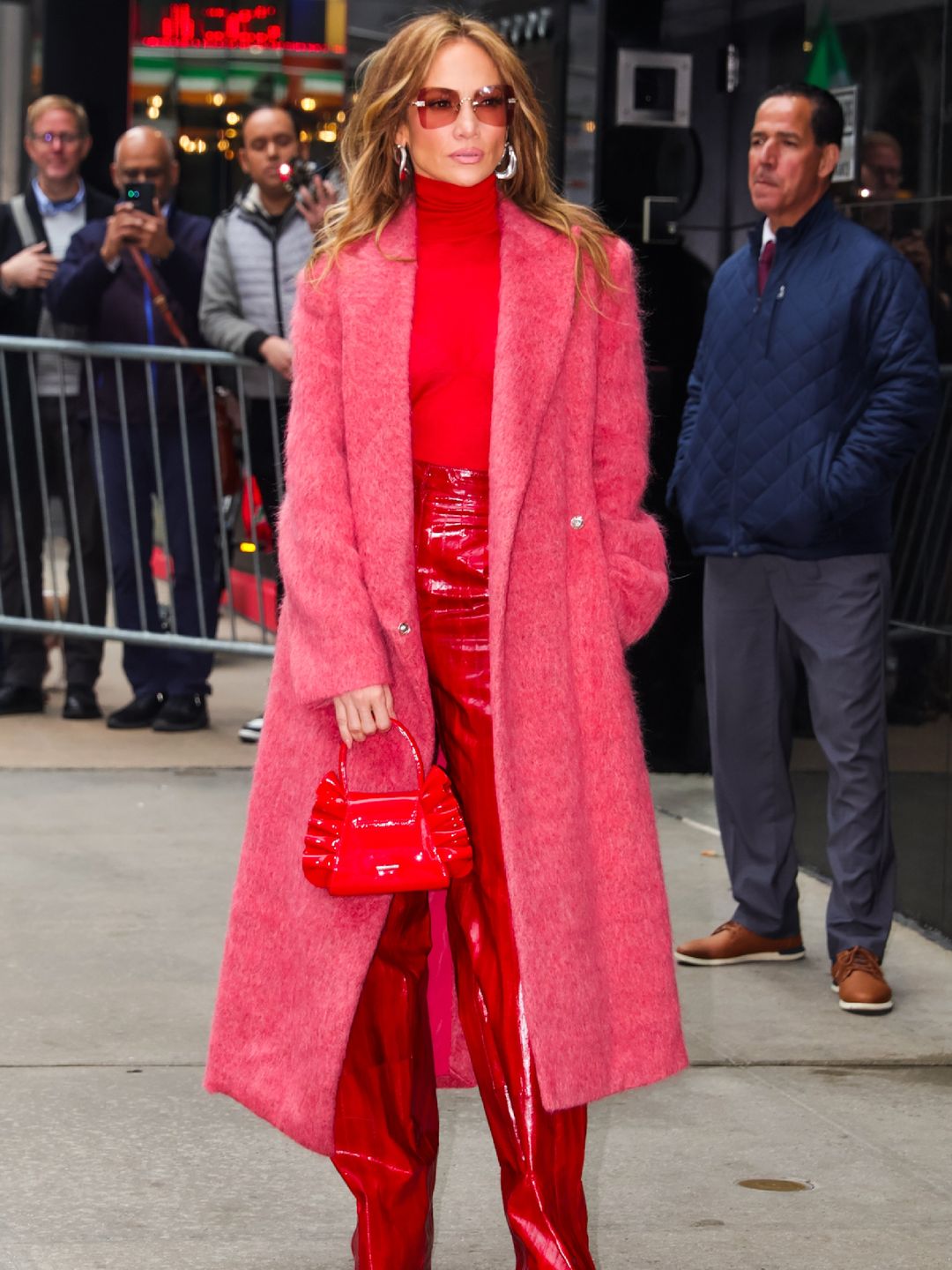 Jennifer Lopez is seen arriving at 'Good Morning America' on May 6, 2024 in New York wearing red trousers, a red turtleneck and a pink coat