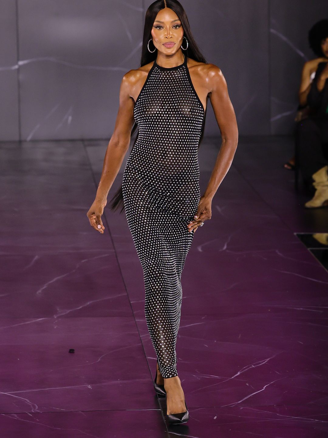 Naomi Campbell wearing a halter dress on the runway 