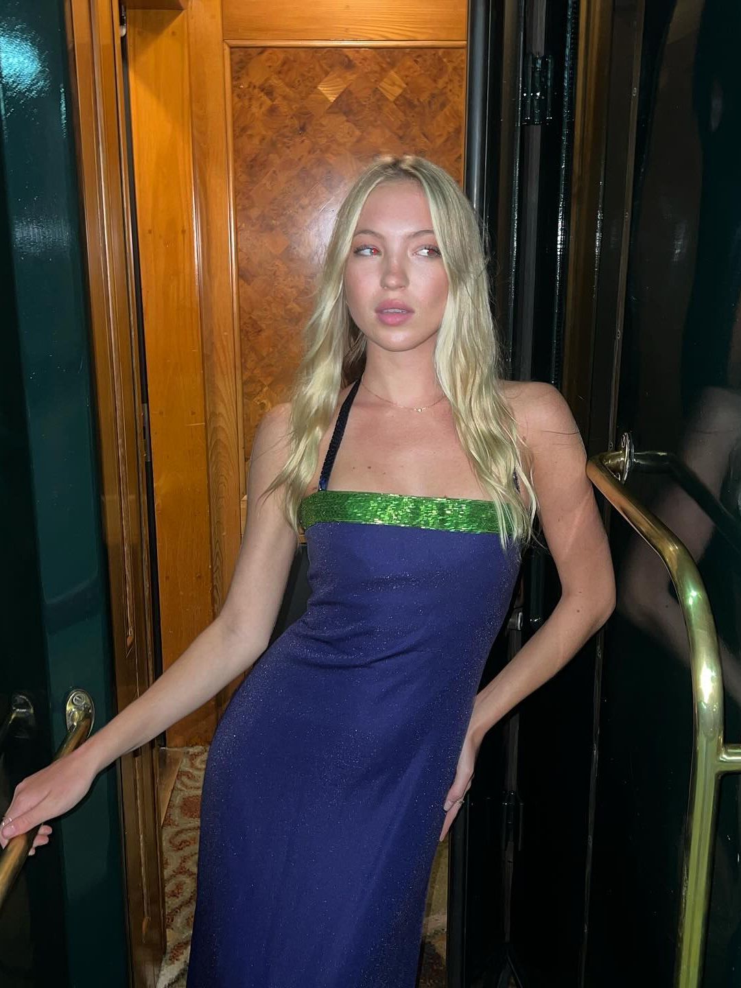 Lila Moss poses in a blue dress with green sequin trim while on holiday 