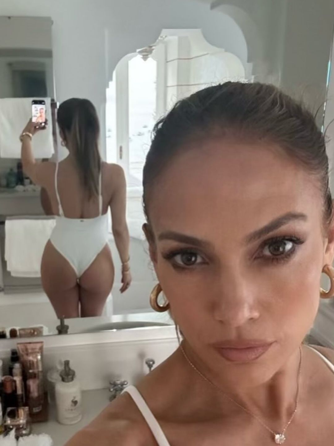 Jennifer Lopez shares an image of herself in a one piece swimsuit