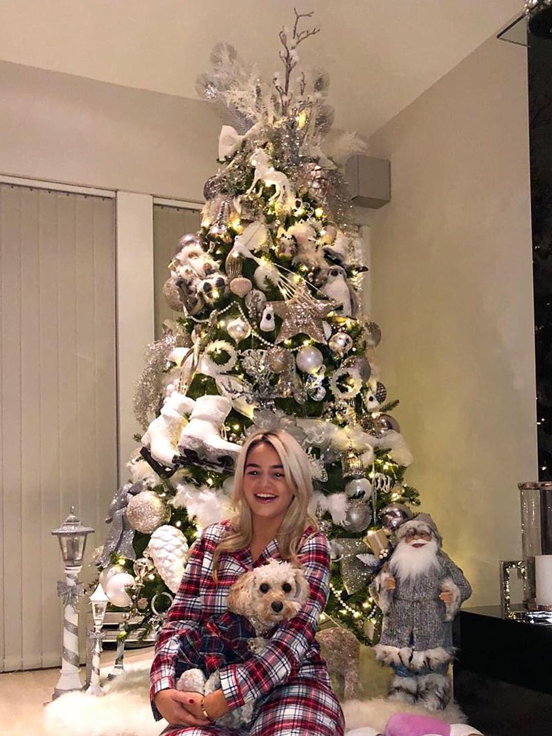 woman posing in front of decorated christmas tree 