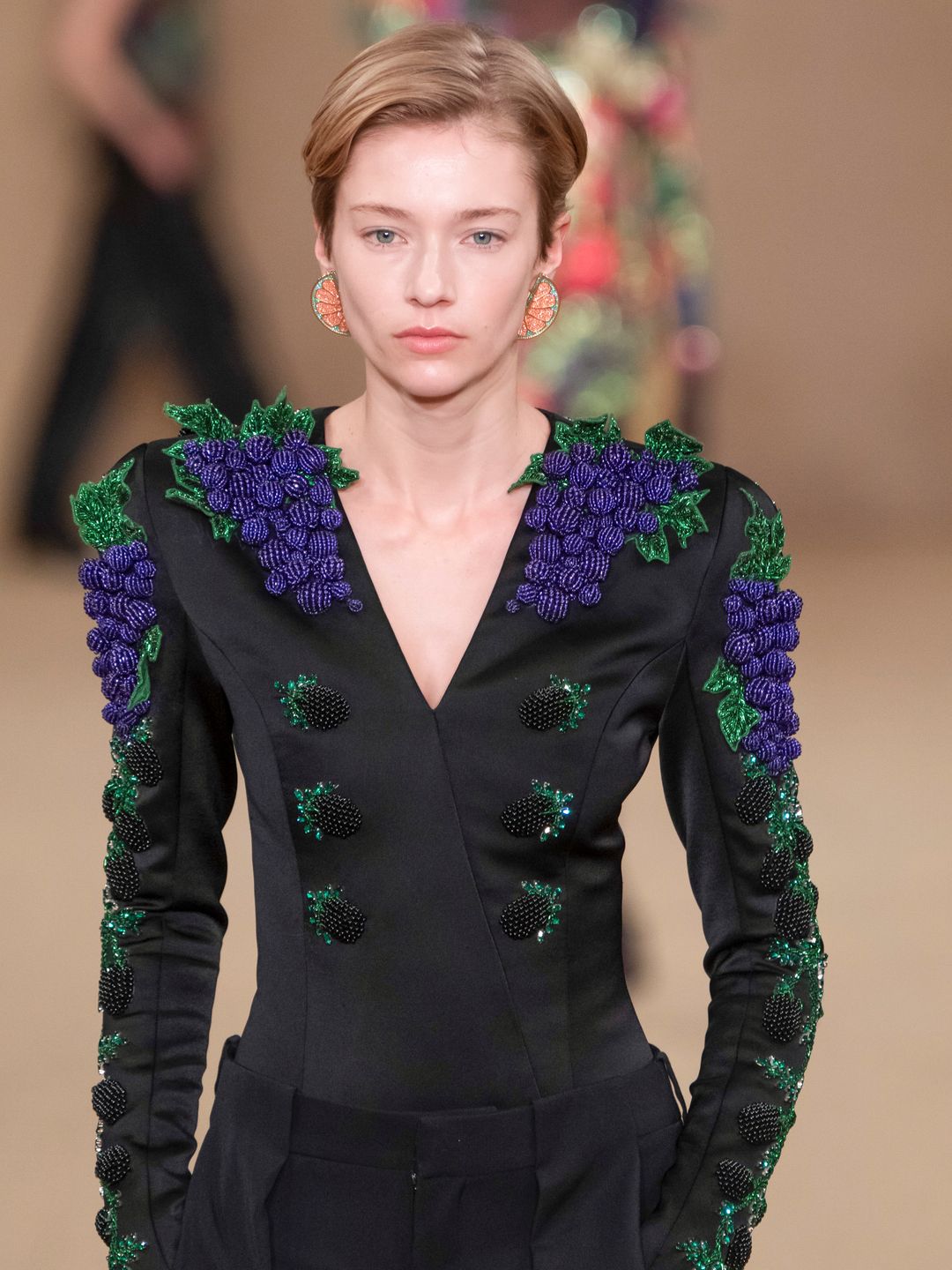  A model walks the runway during the Balmain Ready to Wear Fall/Winter 2024-2025 wearing a blazer adorned with beaded grapes