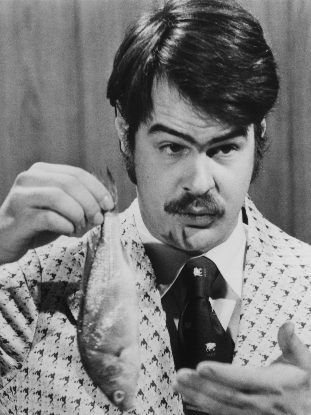 Canadian-American comedian Dan Aykroyd prepares to demonstrate the 'Super Bass-O-Matic' on a sketch from the TV comedy show 'Saturday Night Live', 1976.