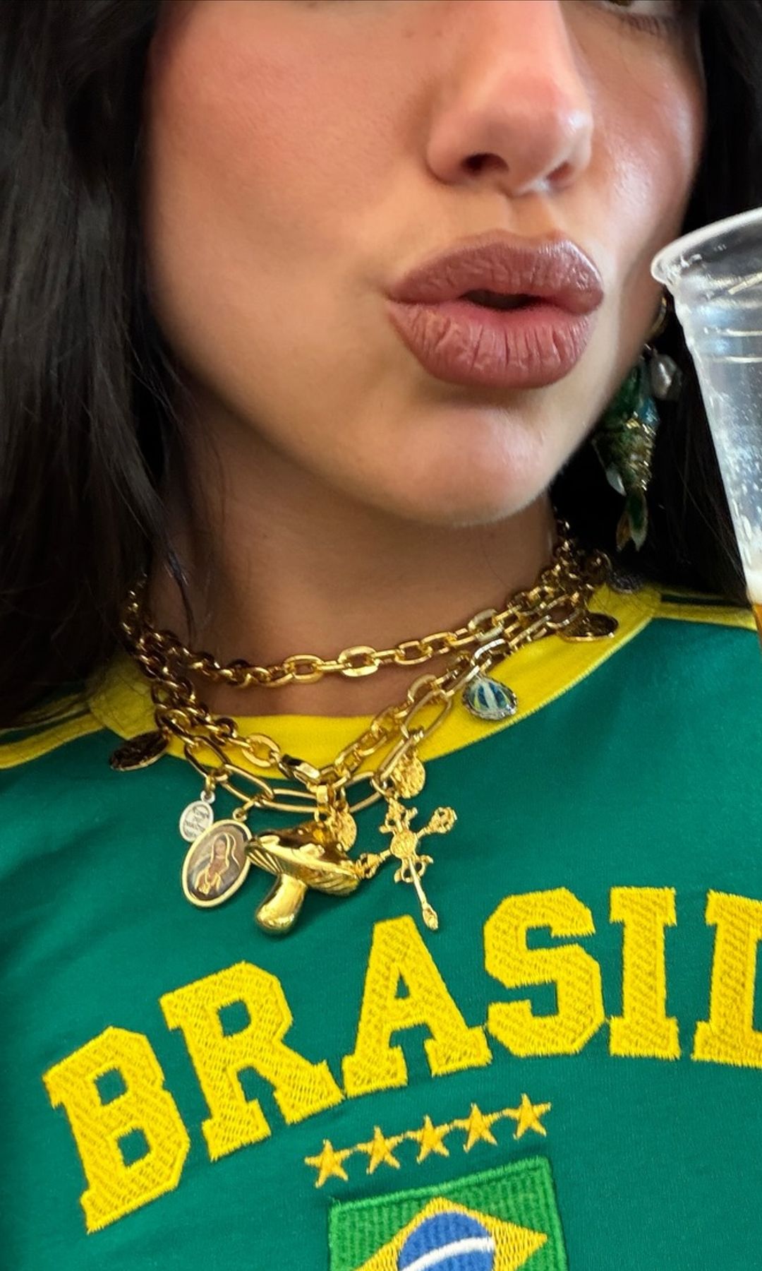 Dua Lipa shares a picture of her Brasil top and gold charm necklace 