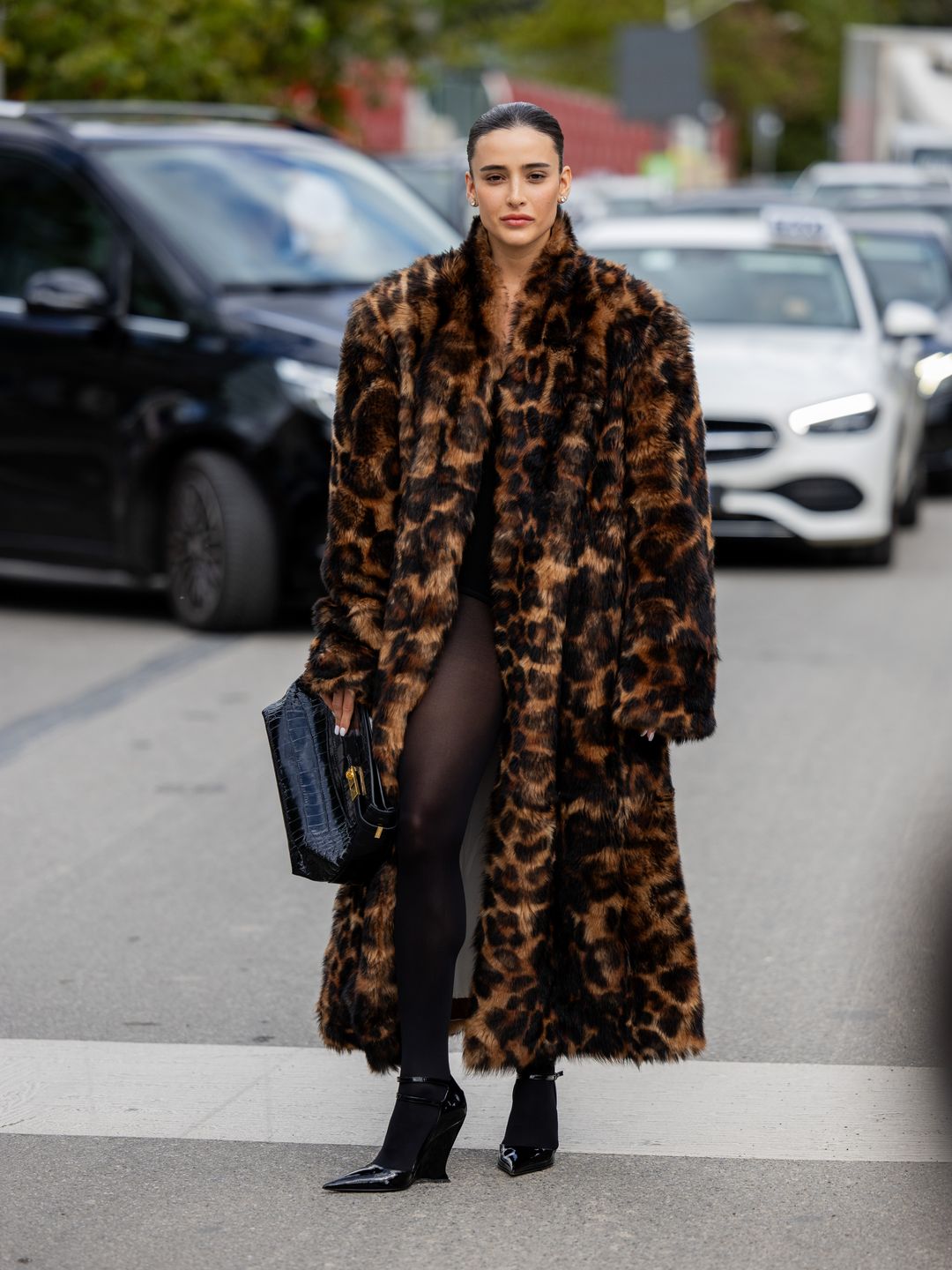 Livia Nunes Marques wears oversized tiger animal print faux fur coat, black bag, tights outside Ferragamo during the Milan Fashion Week - Womenswear Spring/Summer 2024 on September 23, 2023 in Milan, Italy. (Photo by Christian Vierig/Getty Images)