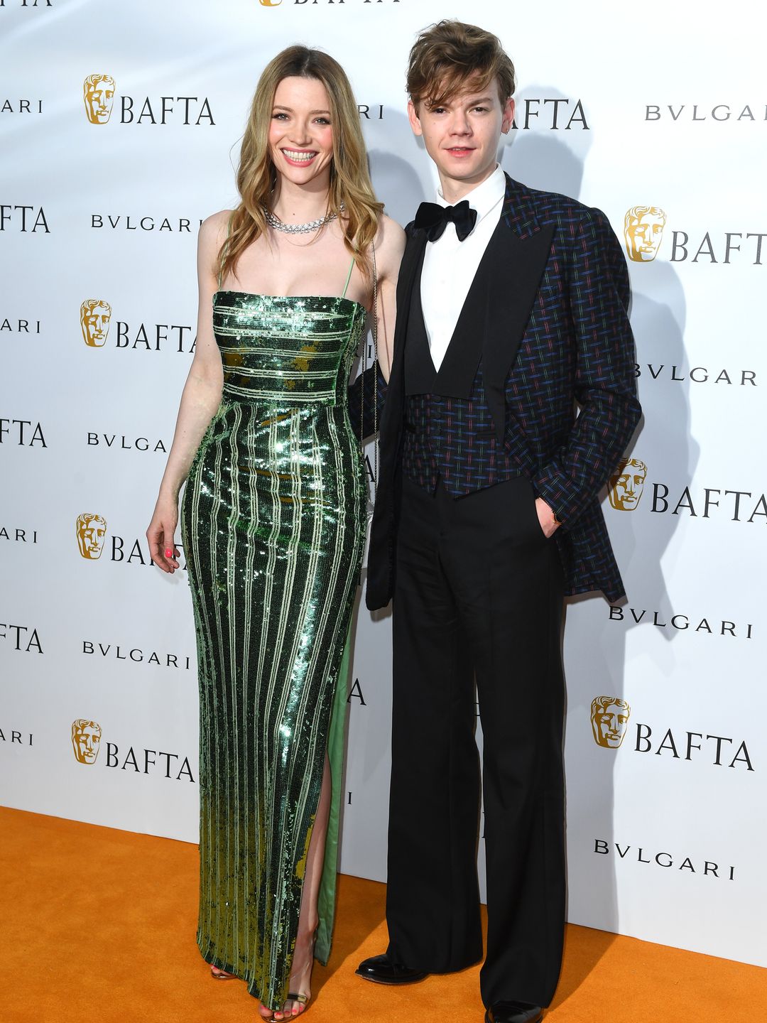 couple dressed smartly on orange carpet