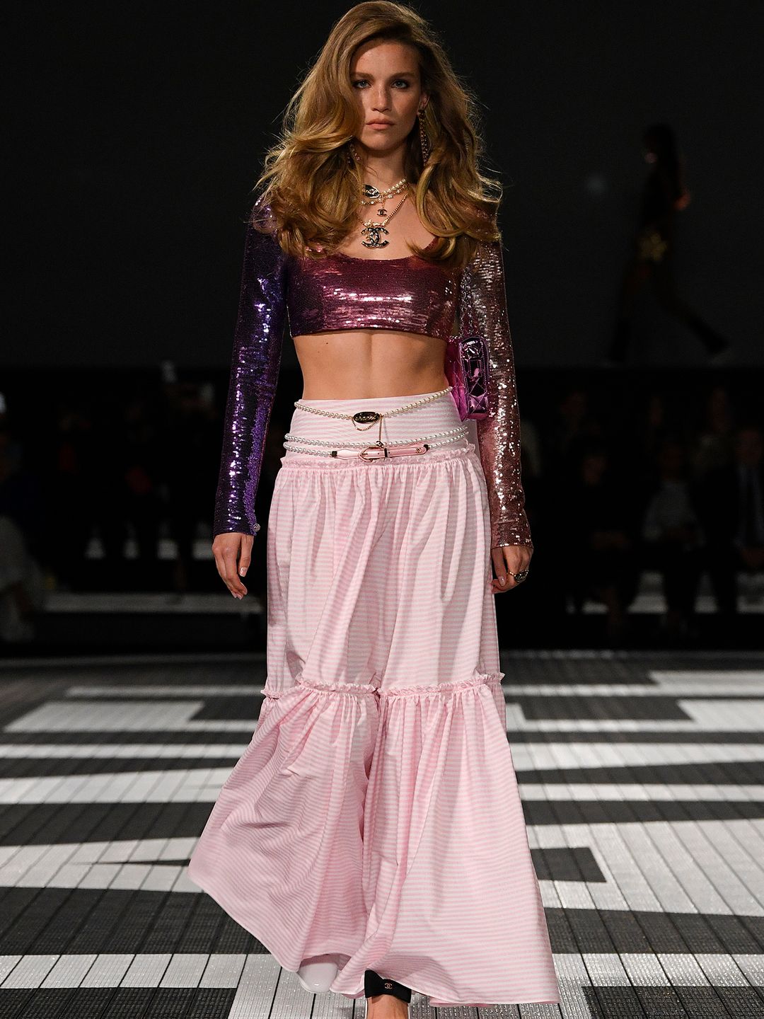 Chanel model wearing cropped sequin top and pink tiered skirt
