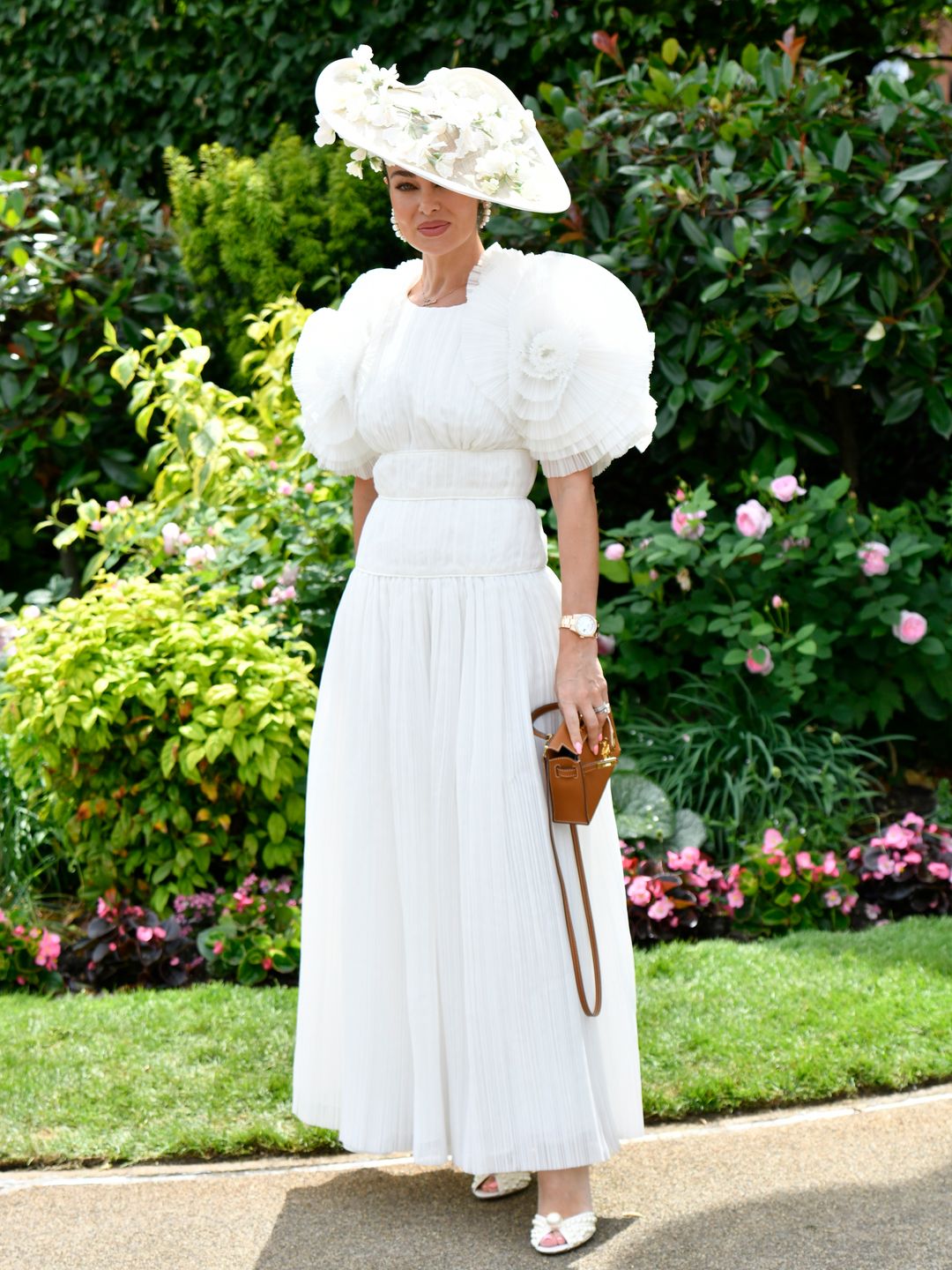 A guest attended day four of Royal Ascot in a white Aje dress and Hermes kelly tan leather handbag. 
