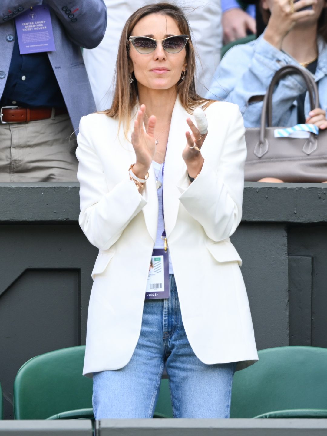 Jelena Djokovic claps in a white blazer and sunglasses during Novak Djokovic's game at Wimbledon 2023