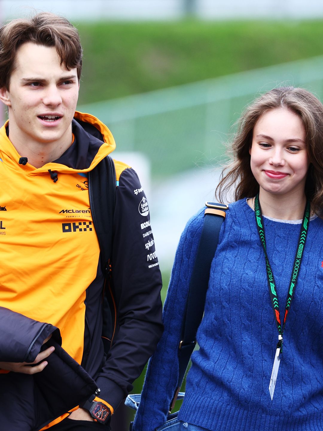 Oscar Piastri and Lily Zneimer walking at an F1 paddock