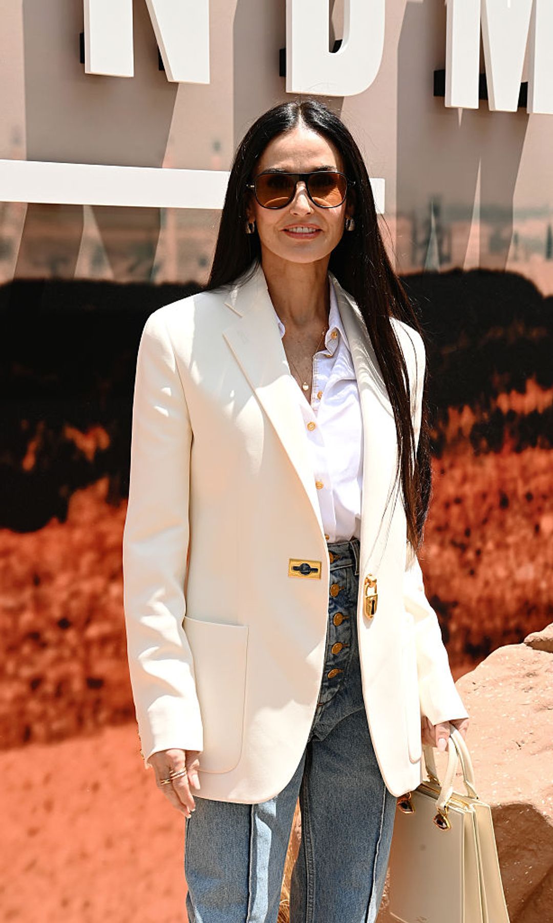 demi moore wearing a white blazer and sleek black hair 