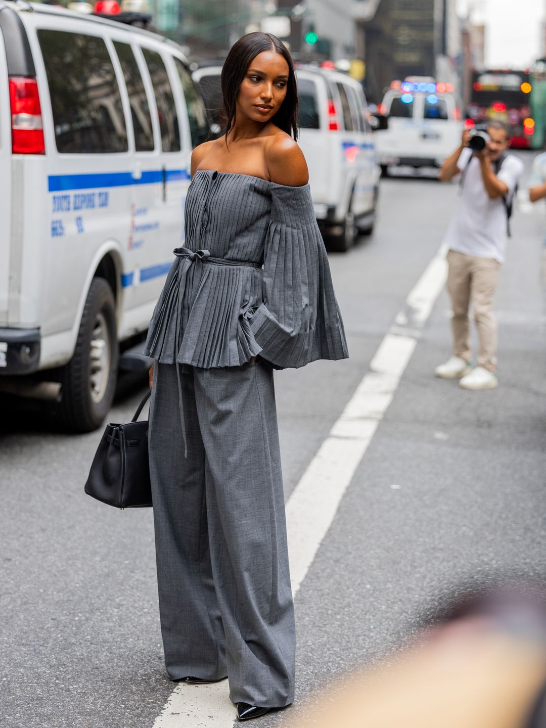 Jasmine Tookes wearing grey pleated top and trousers 