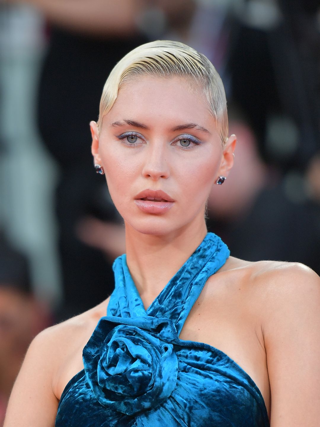 Iris Law wears blue eyeshadow to compliment her blue dress with wet look hair 