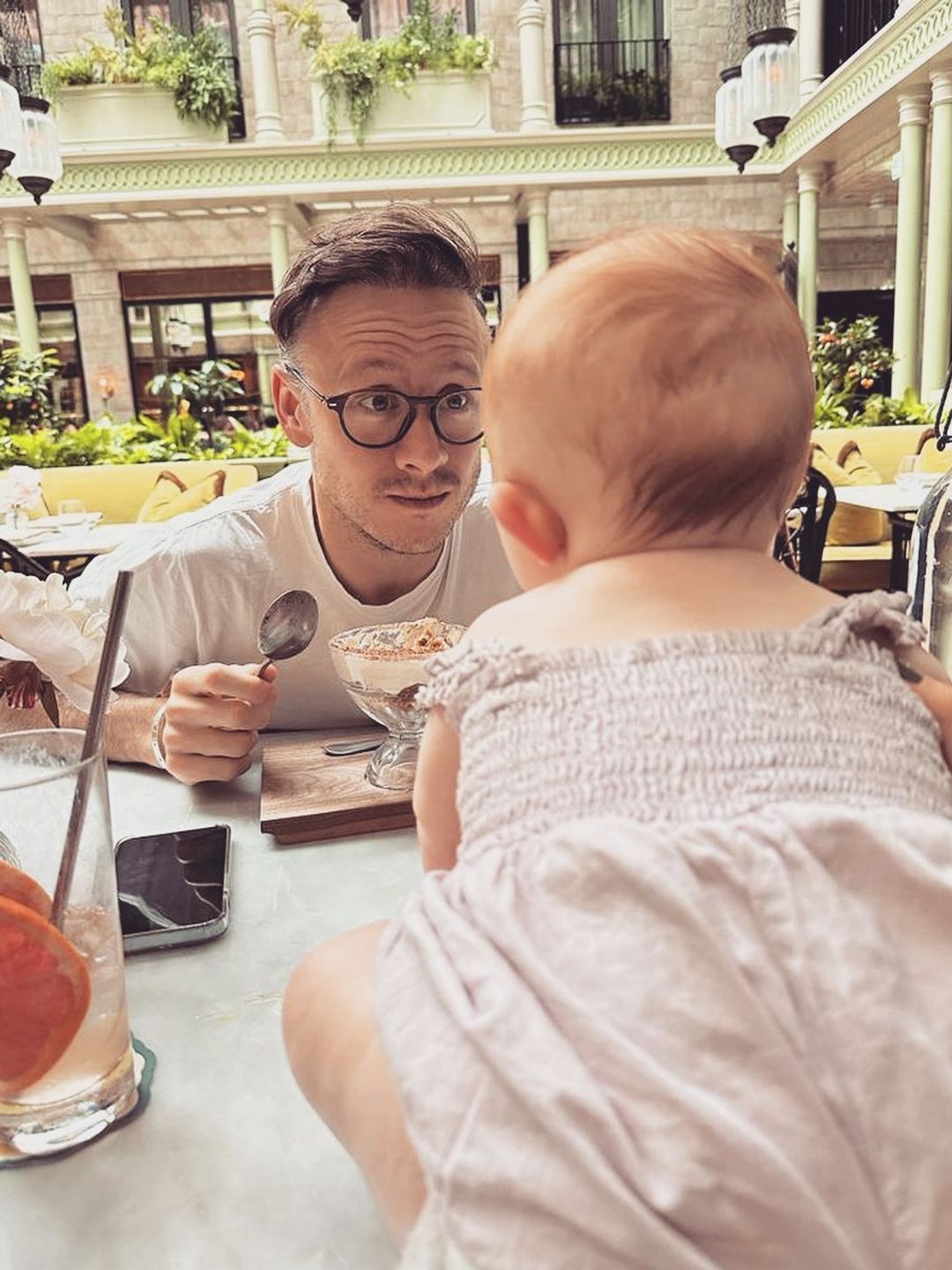 dad talking to baby daughter at table 