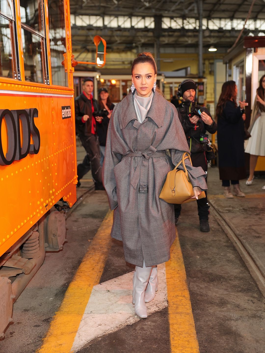 Jessica Alba attends the Tod's fashion show during the Milan Fashion Week in a grey coat and heeled boots