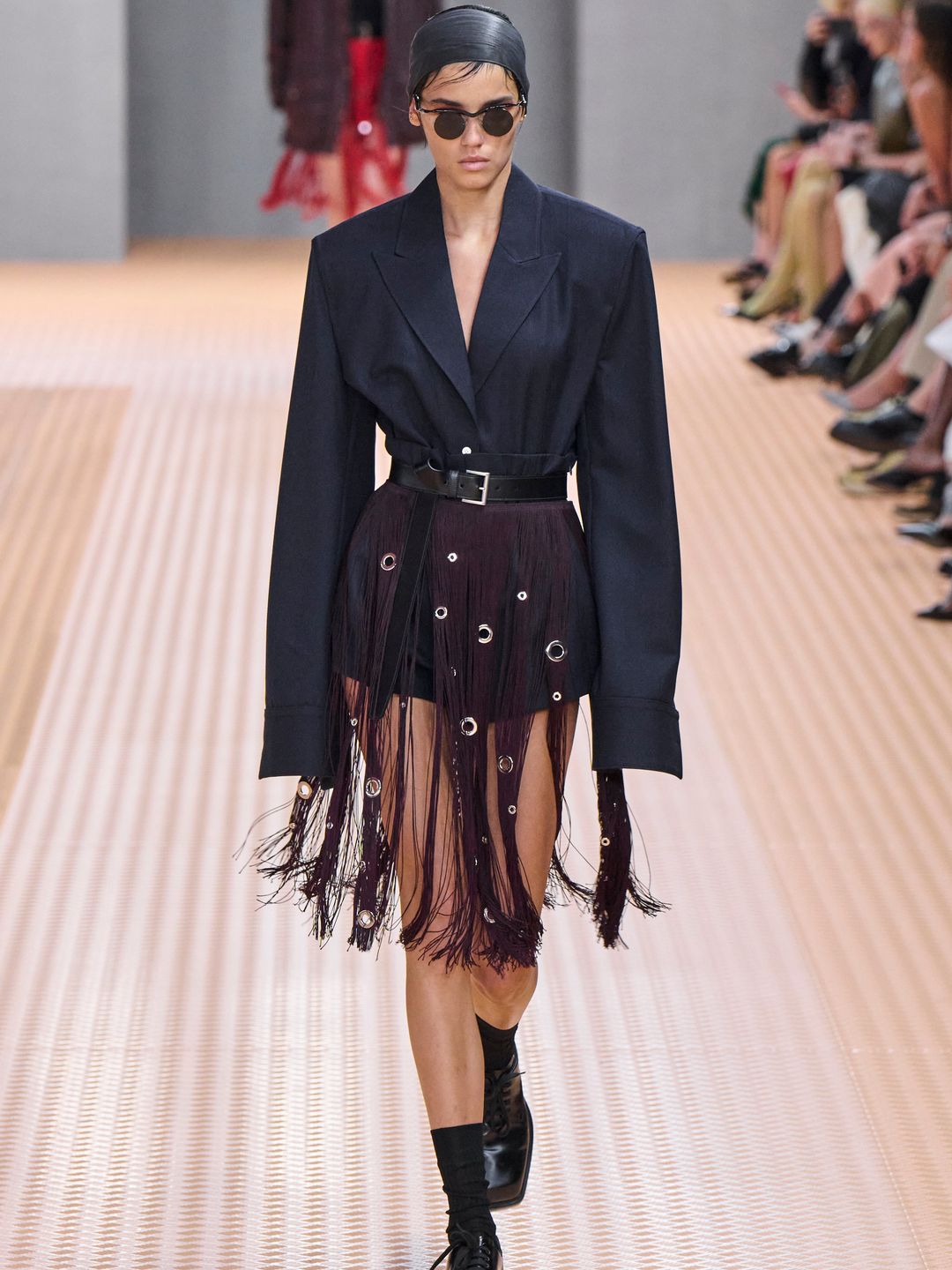Prada SS24 model wears blazer cinched in at the waist with belt 