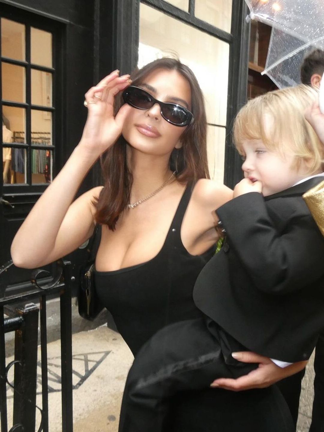 Emily Ratajkowski wearing dark shades with a sleeveless black dress for the occasion