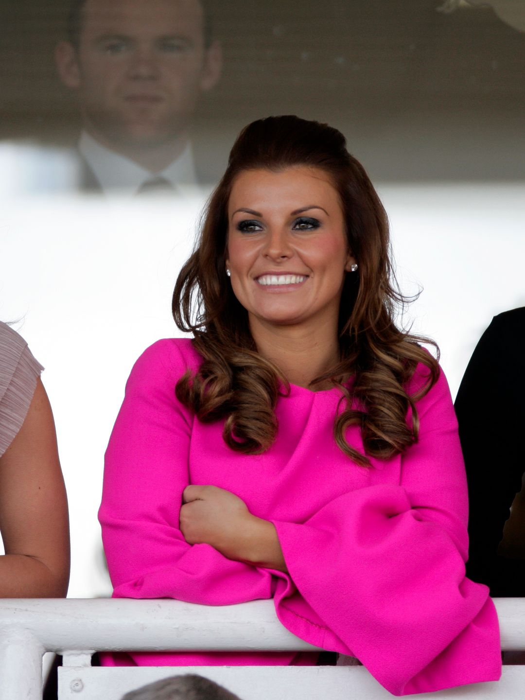 Wayne Rooney looks on, from behind a glass door, as his wife Coleen Rooney watches the races on 'Liverpool Day'