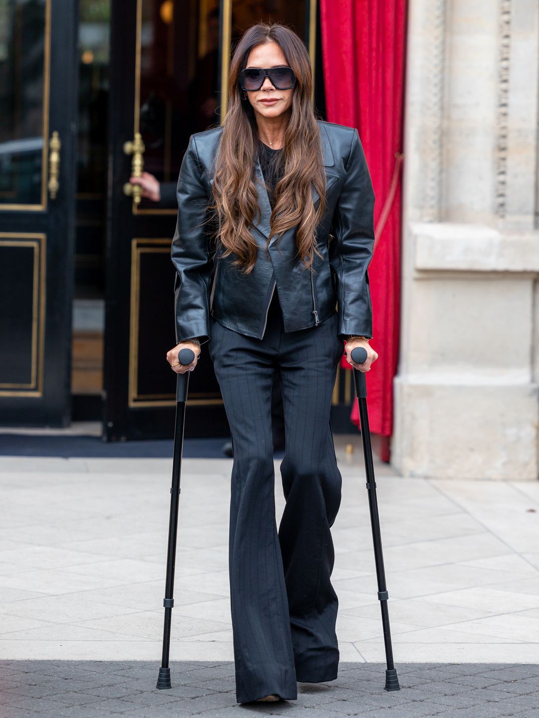 Victoria Beckham walking on crutches in Paris wearing all black 