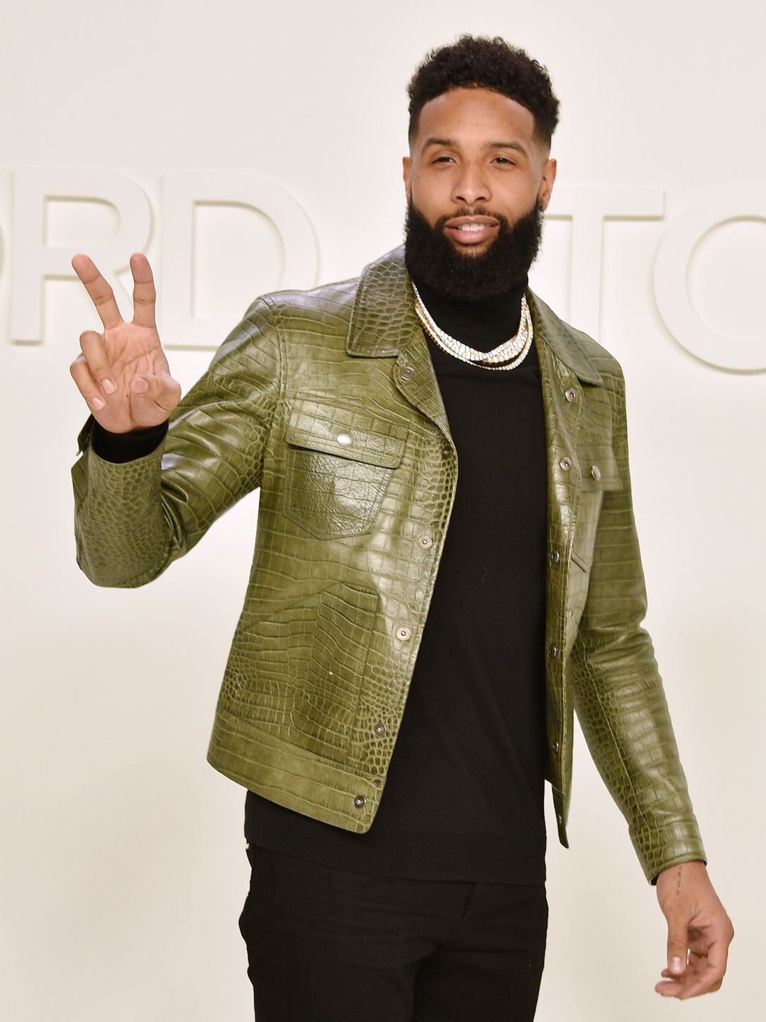 Odell Beckham Jr. attends the Tom Ford AW/20 Fashion Show wearinga black turtle neck and green crocodile skin jacket