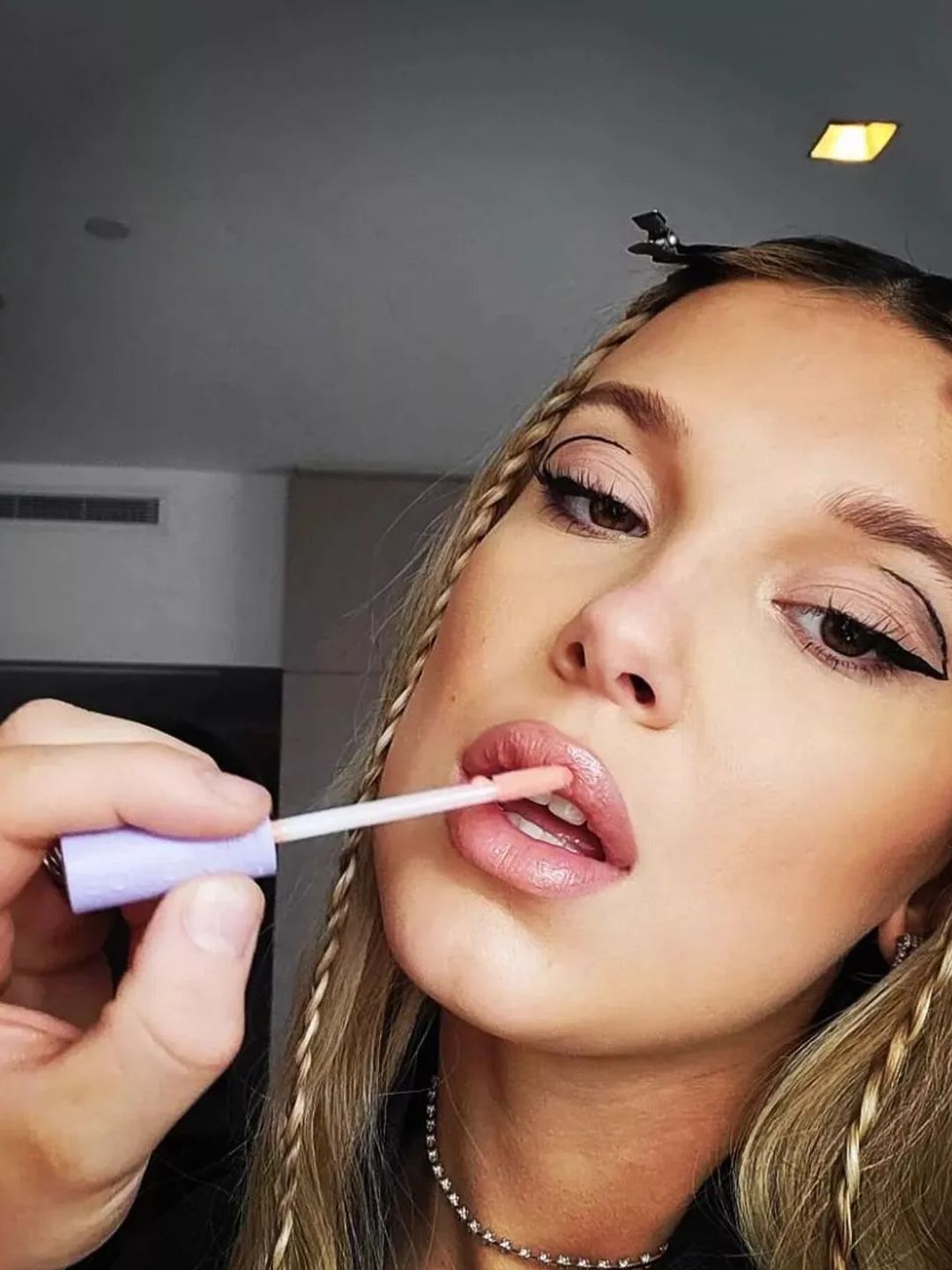 A snapshot from Millie Bobby Brown's Instagram makeup tutorial where she experimented with graphic eyeliner and pastel pink tones.