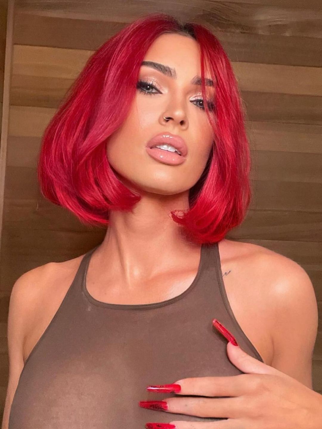 Megan Fox poses with a red bob hairdo and brown tank top on her Instagram