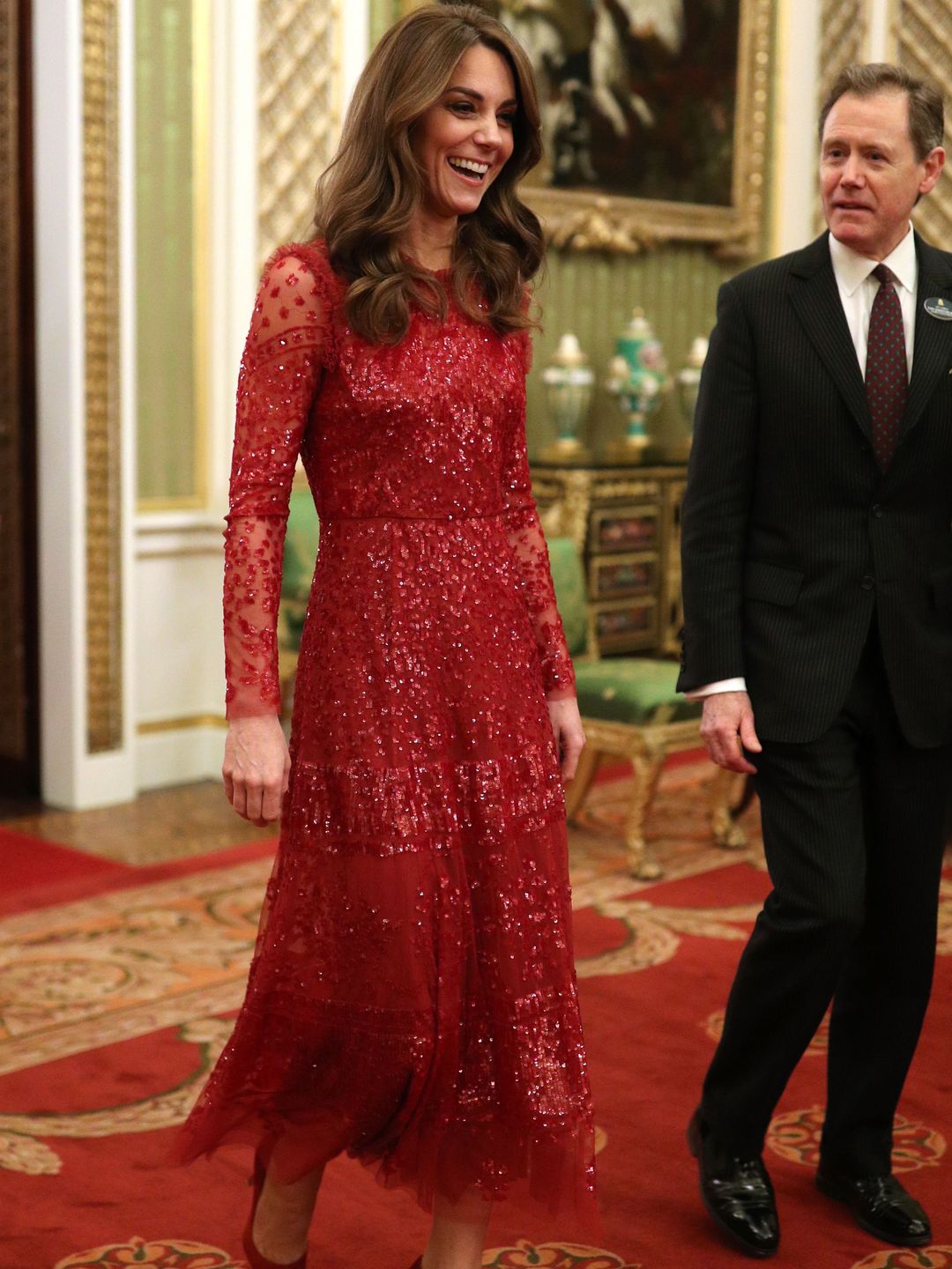Britain's Catherine, Duchess of Cambridge (L) walks through to the State Room at a reception for heads of State and Government at Buckingham Palace wearing Needle & Thread
