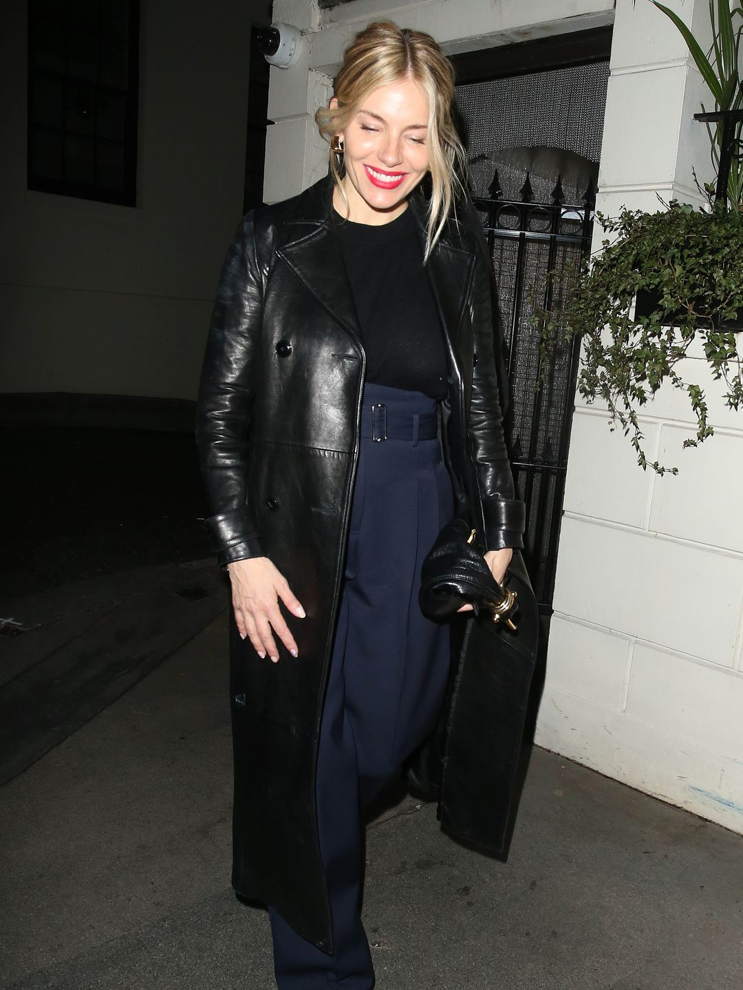 Sienna Miller wearing a glossy trench 