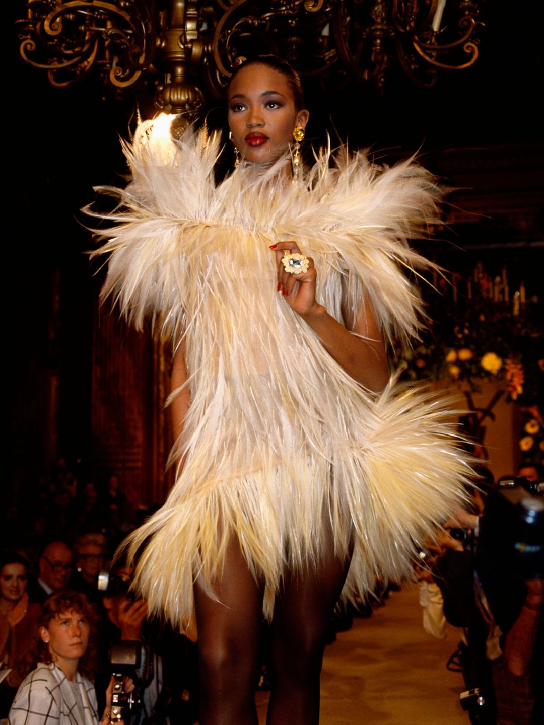 Naomi Campbell wearing a feathered Yves Saint Laurent cocktail dress on the runway 