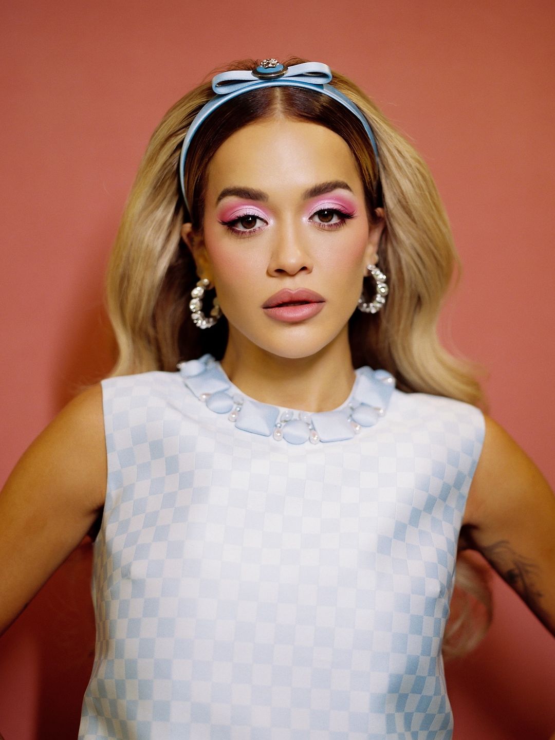 Rita Ora wears a checkered blue and white top with a matching headband on her Instagram