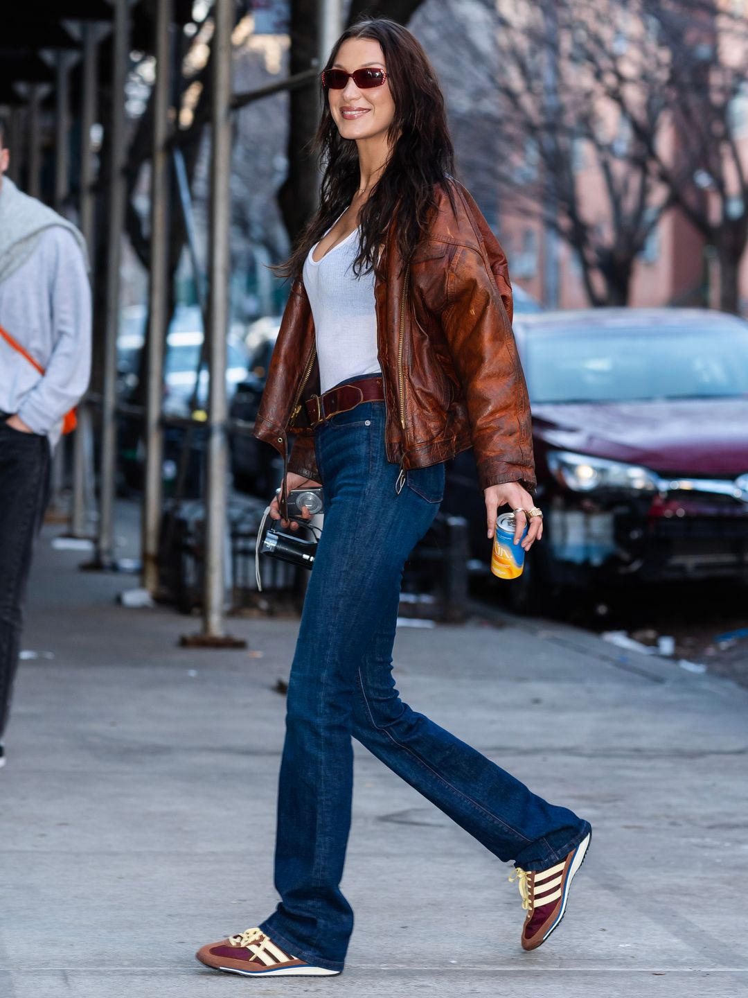 Bella Hadid visits the LES Girls Club wearing Adidas sneakers in brown and yellow