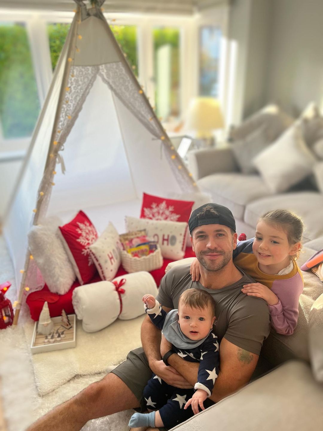 father posing in living room with two children