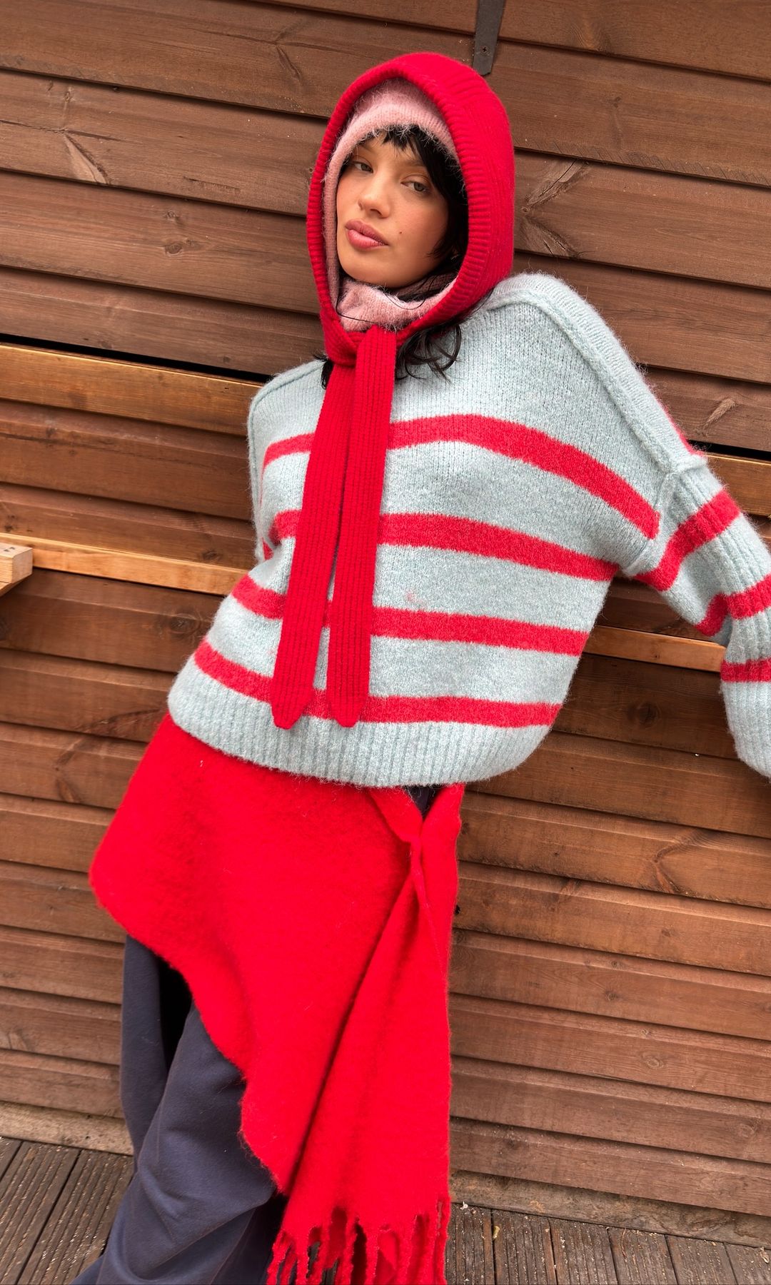 A model poses in knitted hoods and a stripe jumper