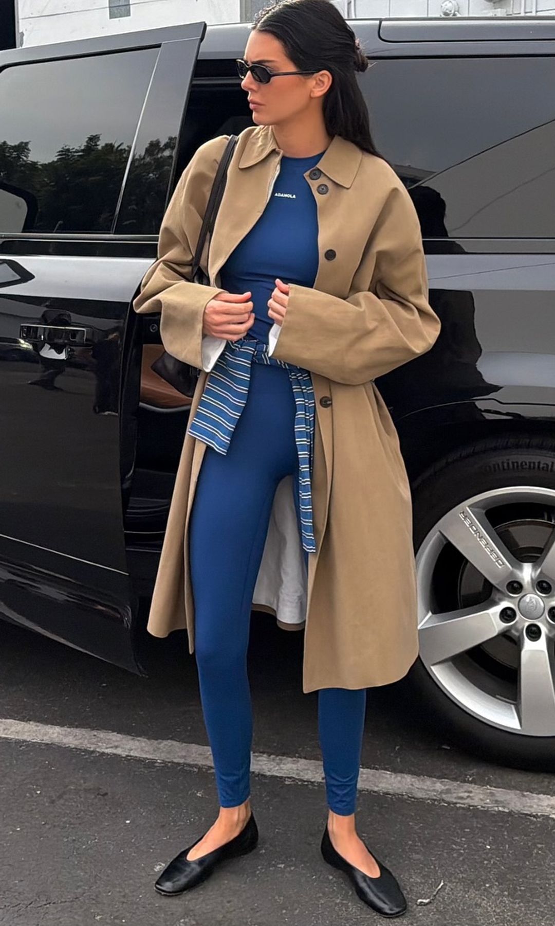 Kendall Jenner is seen wearing a blue workout set, trench coat and sunglasses