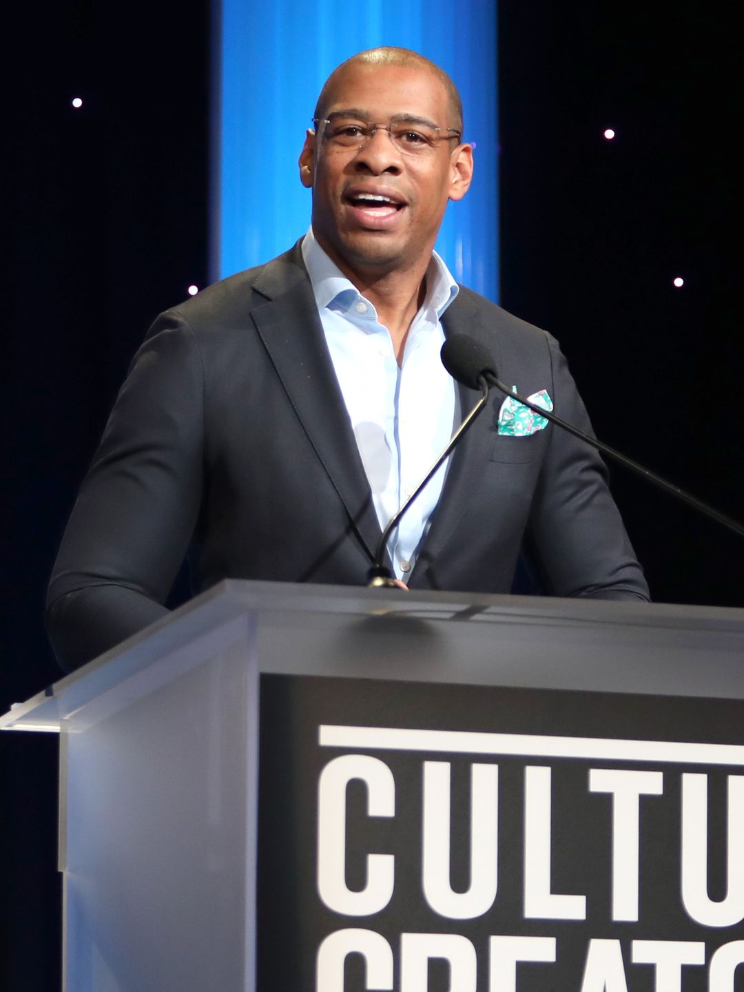 DeMarco Morgan on stage speaking at an event