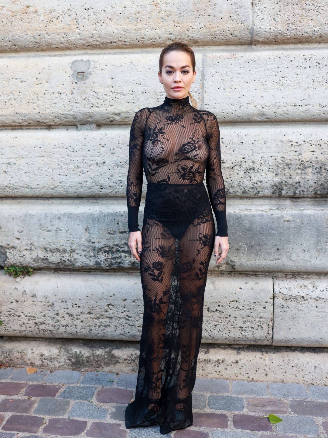 Rita Ora turned heads at the Azzedine Alaïa show in a sheer lace maxi gown, styled with high-waisted knickers and vertiginous platforms.