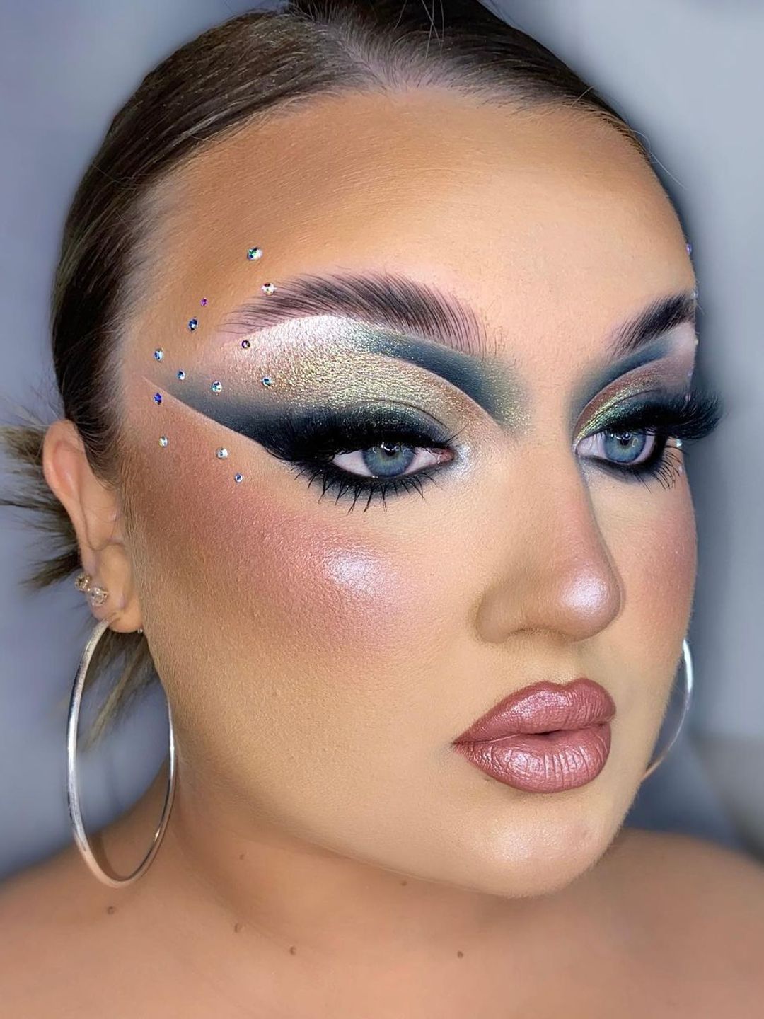 Woman with grey smokey eyeshadow and face gems 