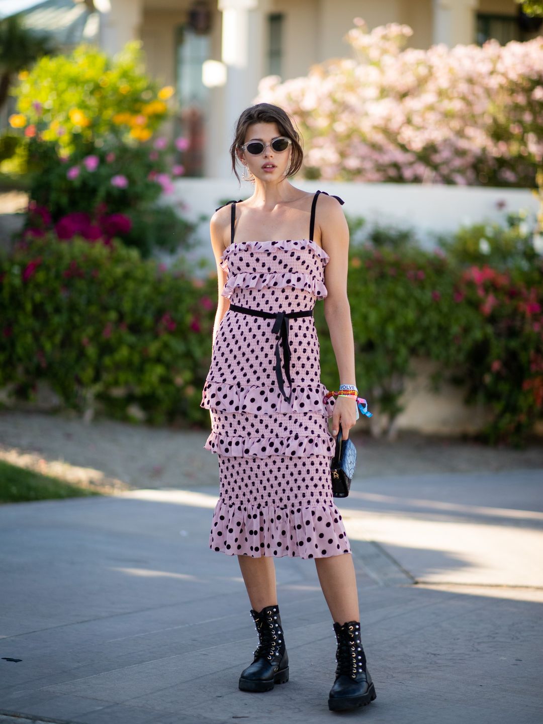 Georgia Fowler is seen wearing pink dress with black dots print, bag, boots at the Revolve Festival during Coachella Festival on April 13, 2019 
