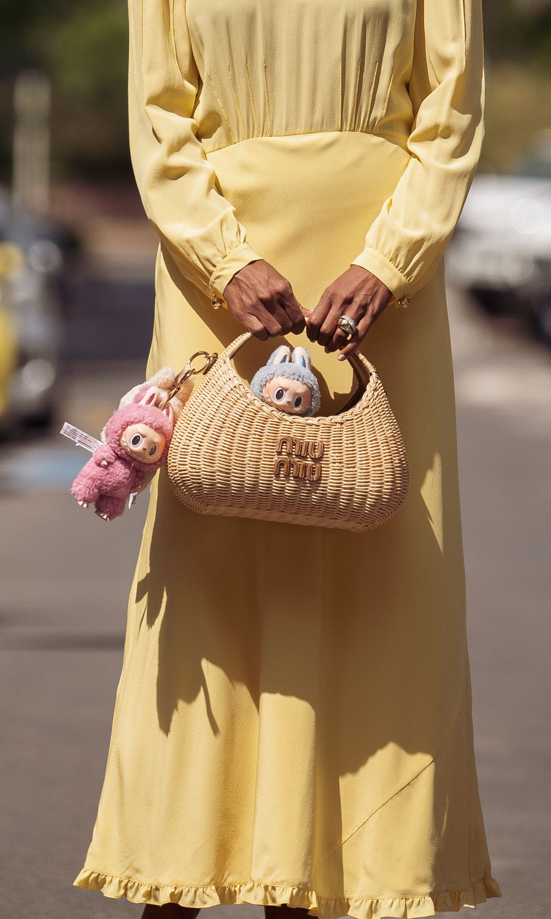 Zufi Alexander porte une pompe blanche avec le charme d'un sac à amour avec tous les charmes Miu Miu, plates-formes, snolgrasses et paille Miu Miu Charms, fabriquée dans une longue robe d'été avec robe jaune au beurre, le 17 mai 2025.