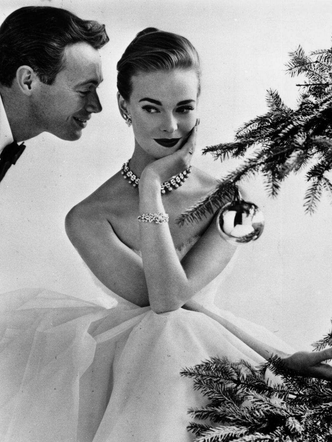 Model Susan Abraham poses beside a Christmas tree, December 1955.