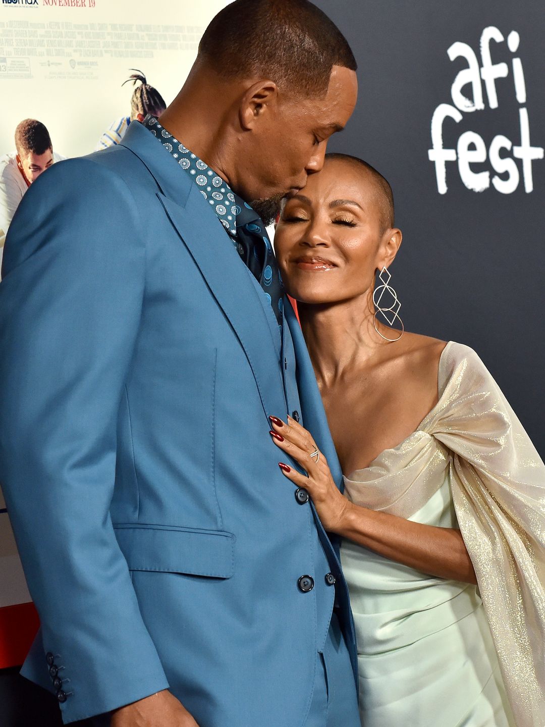 Jada Pinkett Smith and Will Smith cradling each other lovingly while stood for a red carpet photo