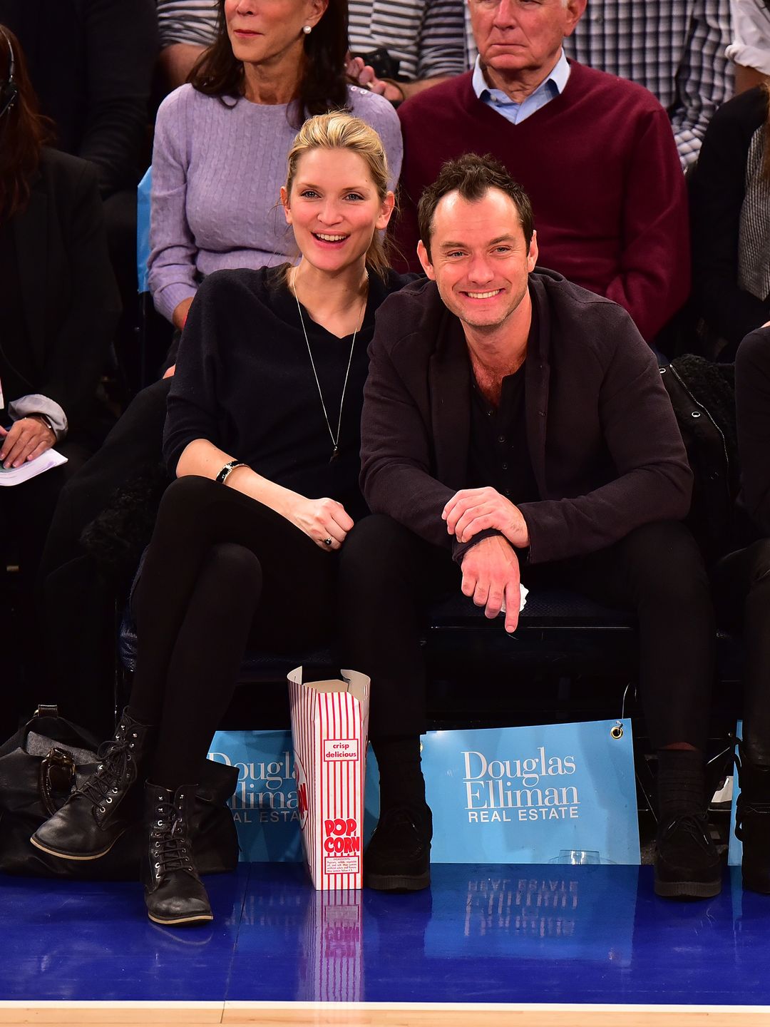Jude and Phillipa smiling courtside at a basketball game
