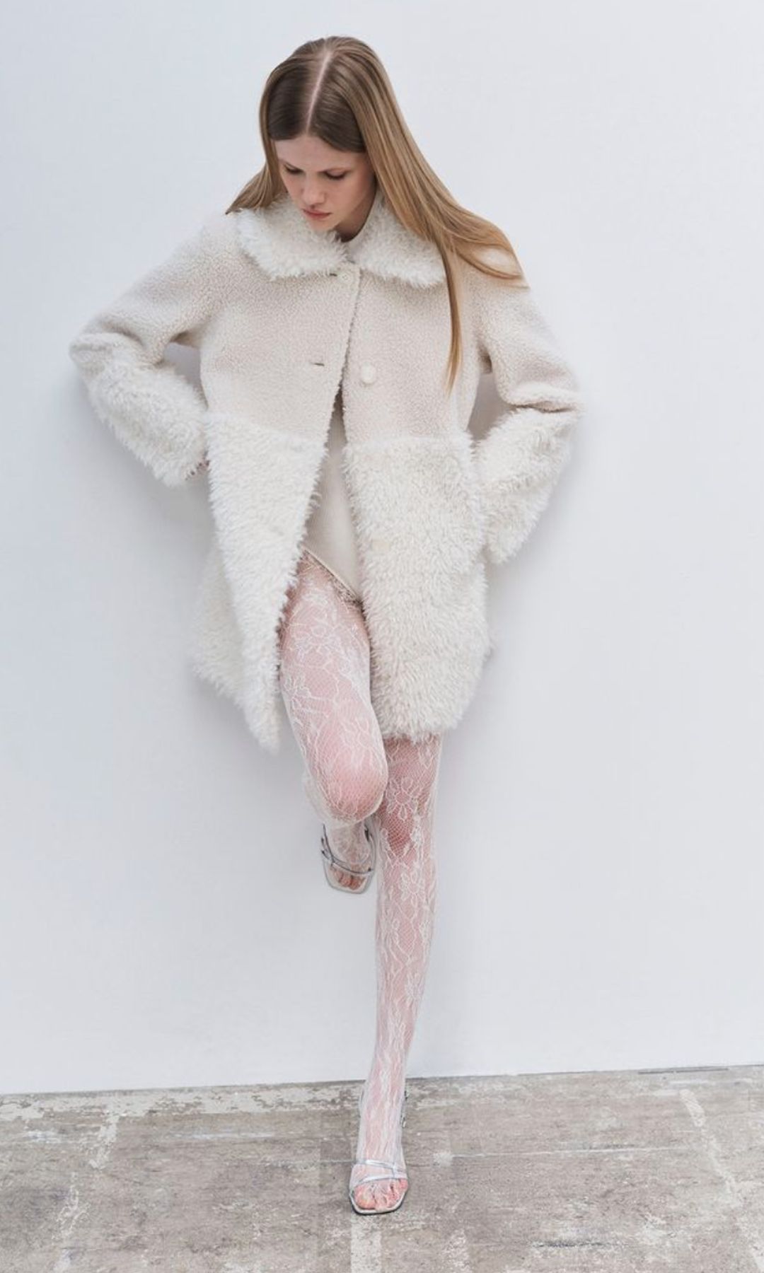 model in white lace tights and shearling coat