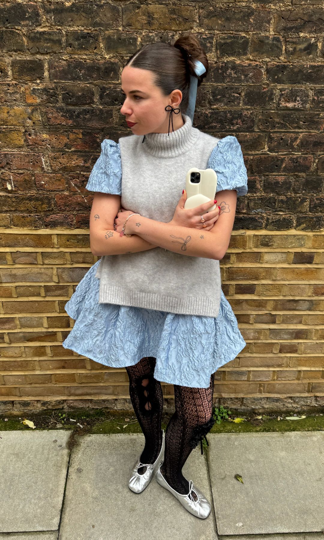 Orion wearing silver ballet flats with tights and a blue dress