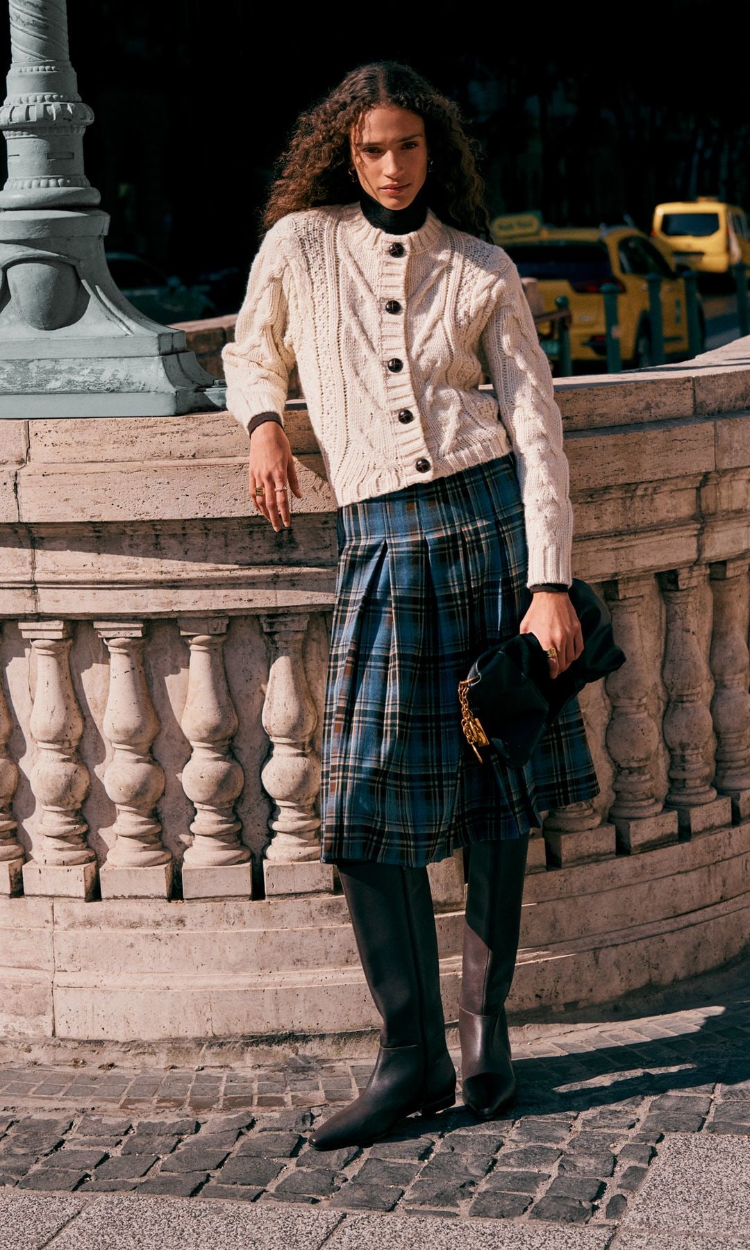 model in chunky cardigan and tartan skirt